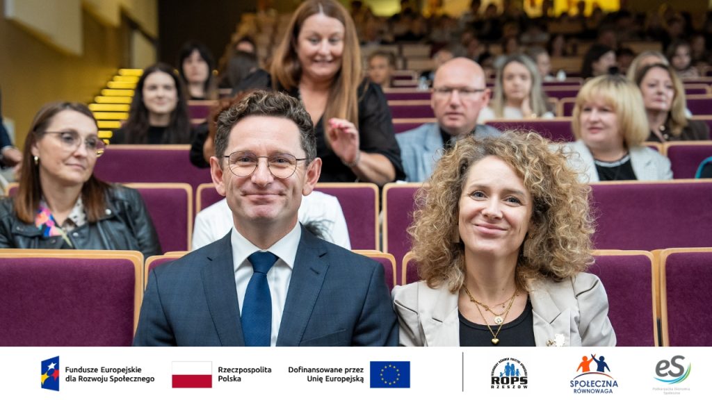 Uśmiechnięci ludzie słuchający przemówienia