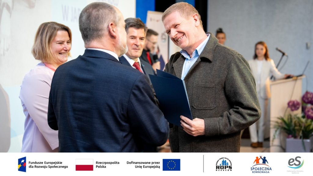 Uśmiechnięty mężczyzna odbiera nagrodę