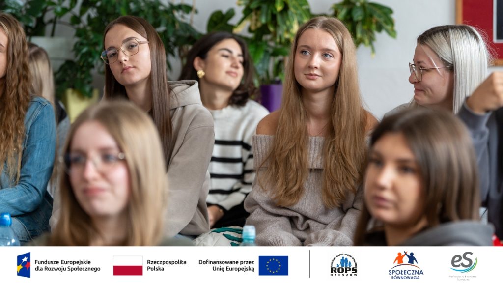 zdjęcie grupy nastolatków siedzących na biurkach