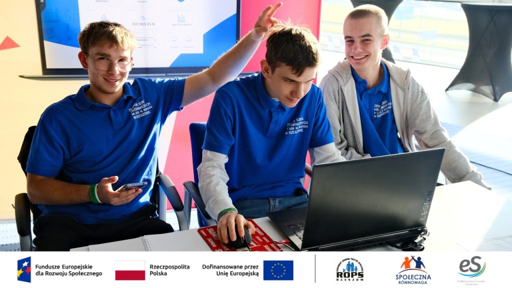 Uśmiechnięta grupa ludzi pracujących przy komputerach