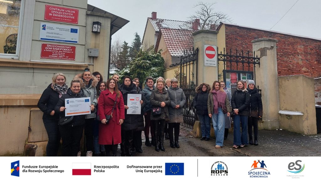 Ludzie pozujący przy bramie wjazdowej