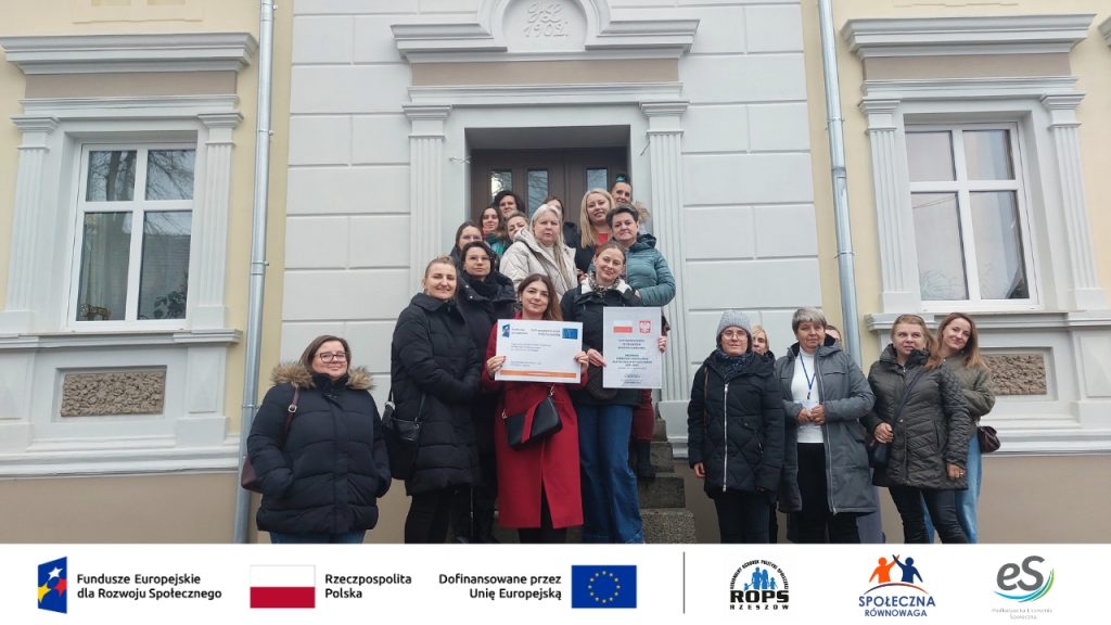 Grupa ludzi pozujących przed budynkiem studia