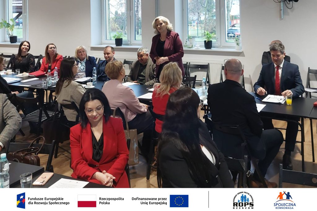 Grupa ludzi czytających dokumenty na sali konferencyjnej