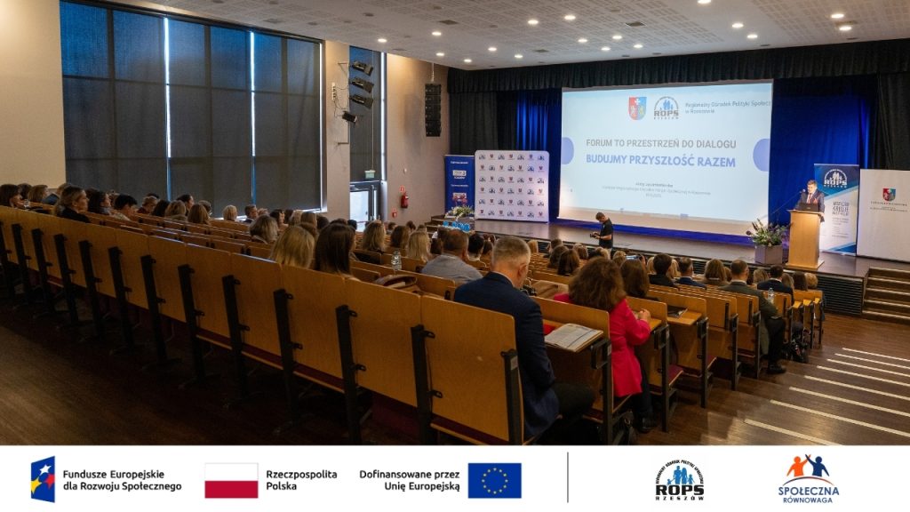 Zdjęcie gości na auli oraz sceny