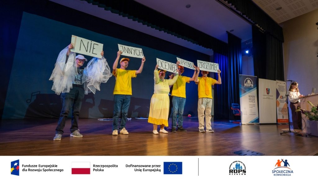 Zdjęcie ludzi trzymających opis na scenie