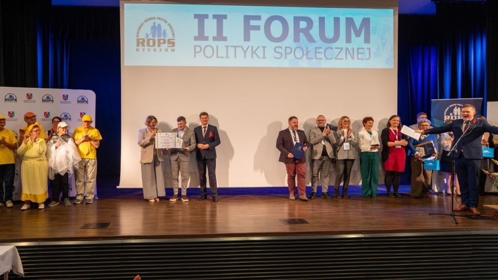 Zdjęcie ludzi na scenie po odebraniu nagród