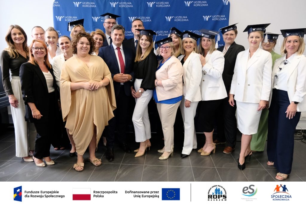 Grupa ludzi pozująca do zdjęcia z czapkami studenckimi