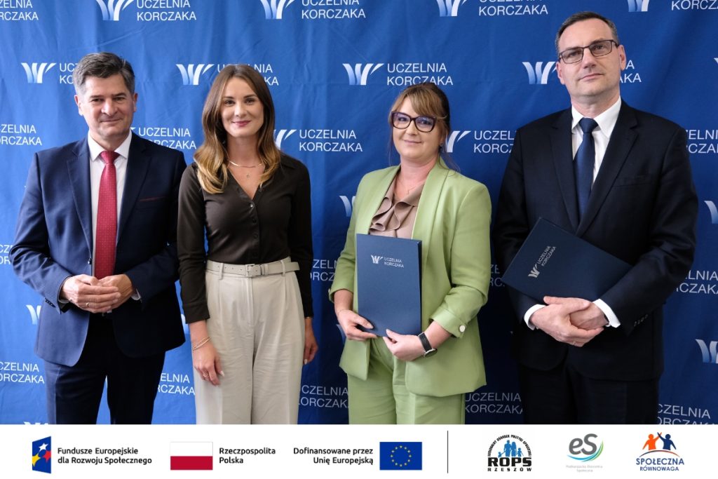 Grupa ludzi pozująca do zdjęcia z dokumentami