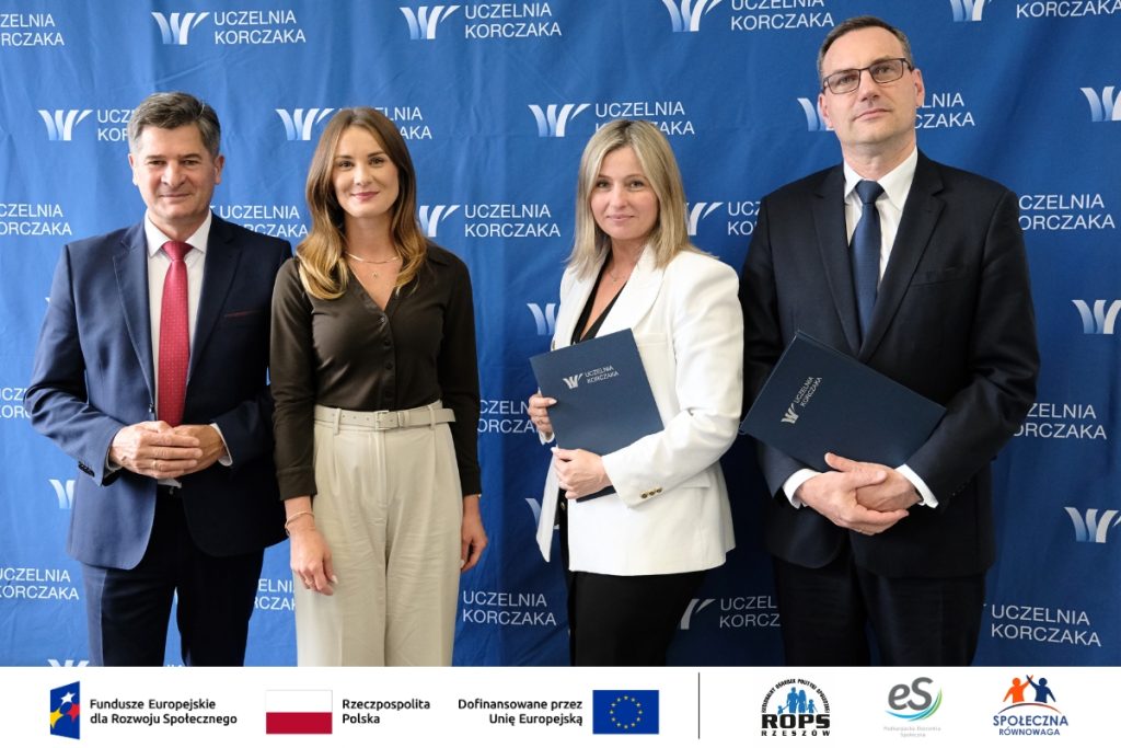 Grupa ludzi pozująca do zdjęcia z dokumentami