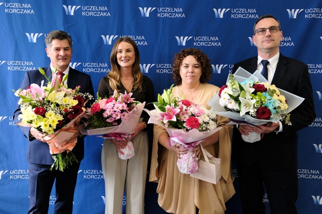 Grupa ludzi pozująca do zdjęcia z bukietami