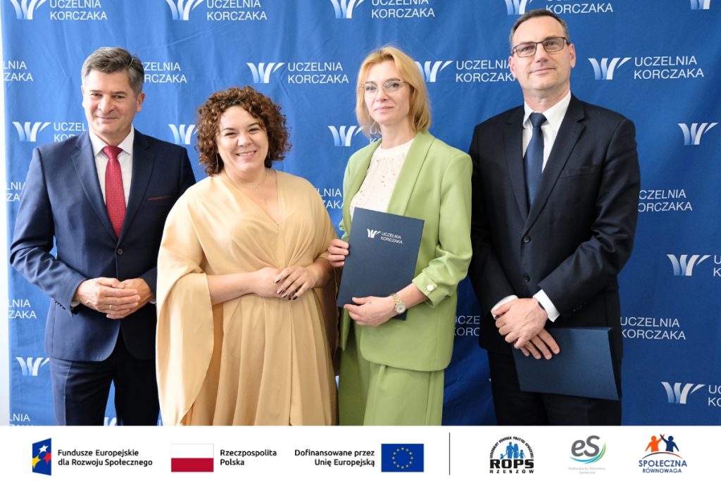 Grupa ludzi pozująca do zdjęcia z dokumentami