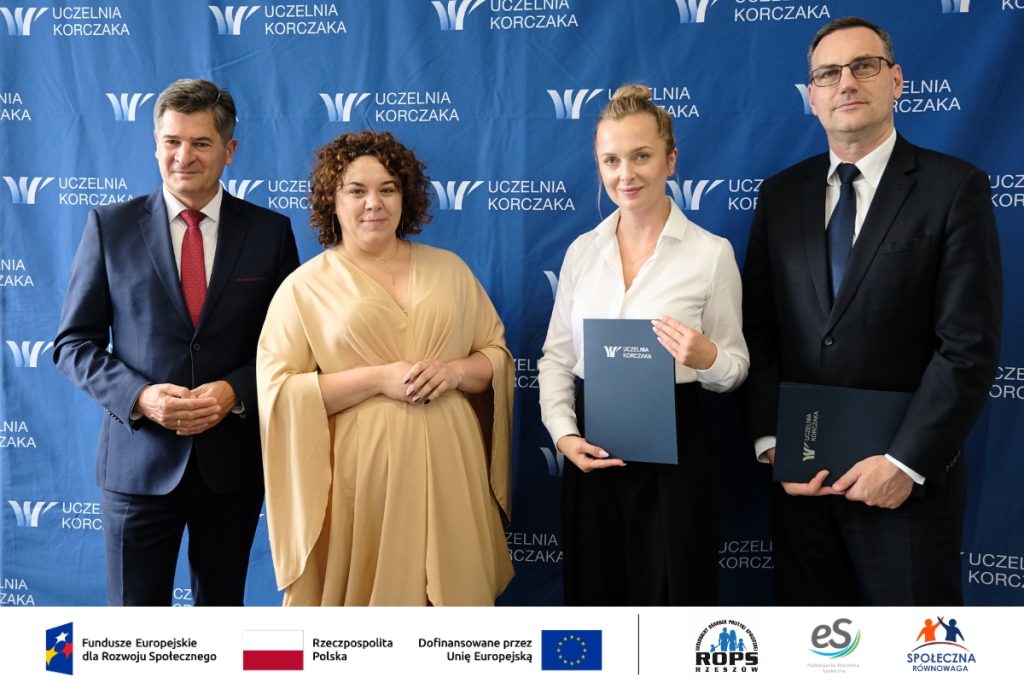 Grupa ludzi pozująca do zdjęcia z dokumentami