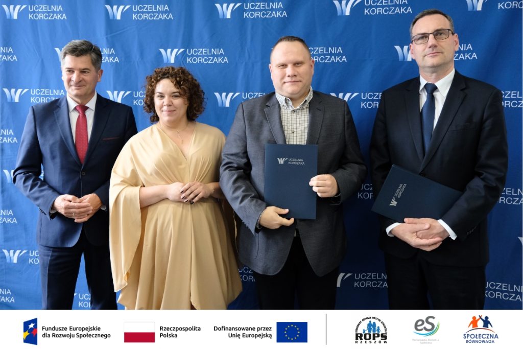 Grupa ludzi pozująca do zdjęcia z dokumentami