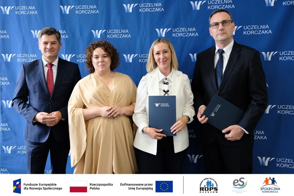 Grupa ludzi pozująca do zdjęcia z dokumentami
