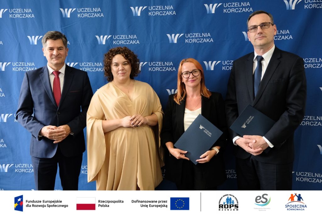 Grupa ludzi pozująca do zdjęcia z dokumentami