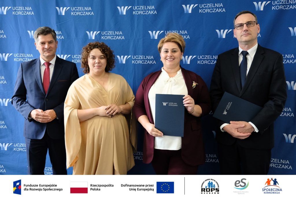 Grupa ludzi pozująca do zdjęcia z dokumentami