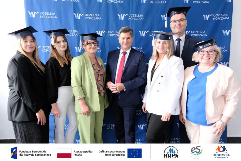 Grupa ludzi pozująca do zdjęcia z czapkami studenckimi