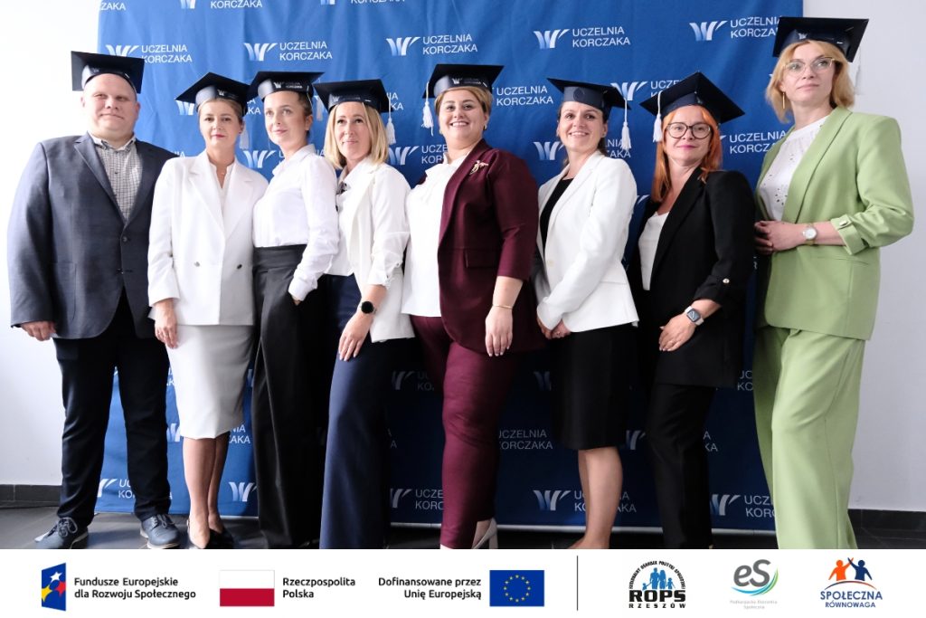 Grupa ludzi pozująca do zdjęcia z czapkami studenckimi